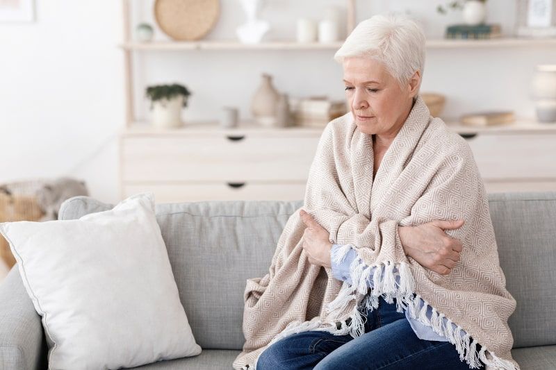 Woman wrapped in blanket on a couch Woman wrapped in blanket on a couch