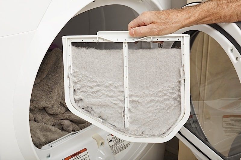 Hand holding lint-filled dryer filter Hand holding lint-filled dryer filter