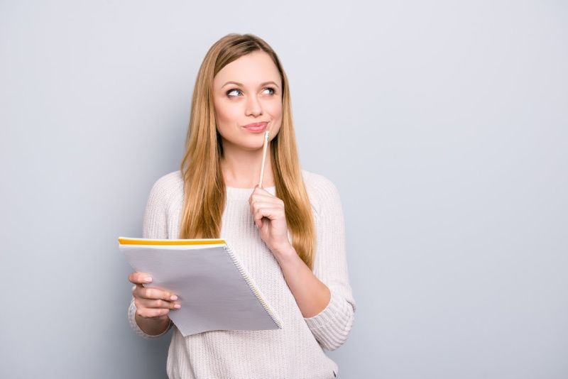 Woman in sweater holding a notebook