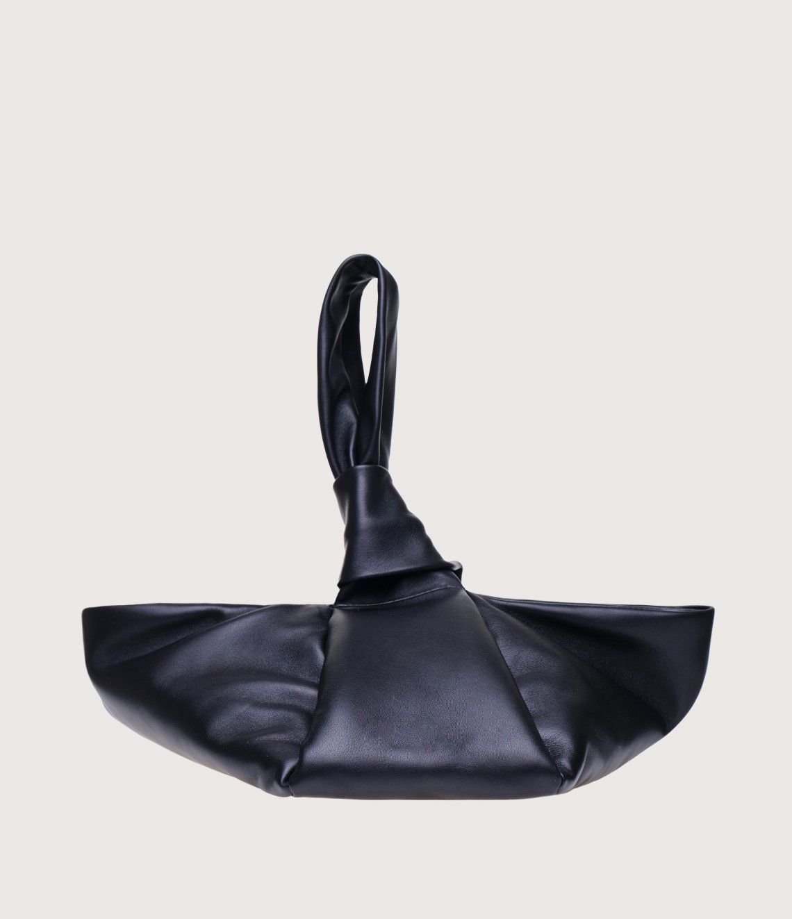 A black leather bag with a knotted handle on a white background.