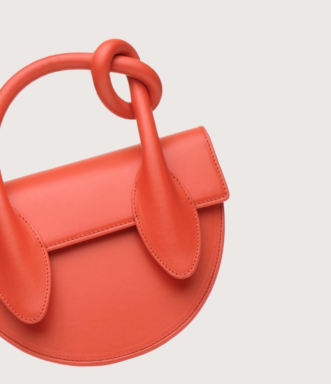 A red purse with a knot in the handle