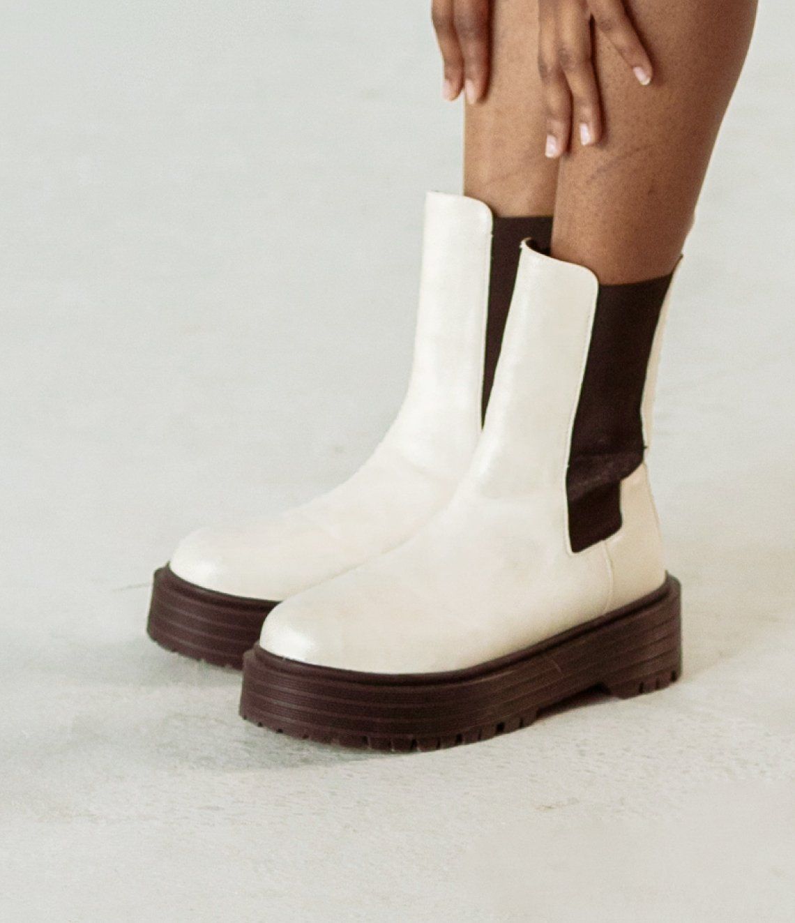 White leather Chelsea boot with black chunky sole.