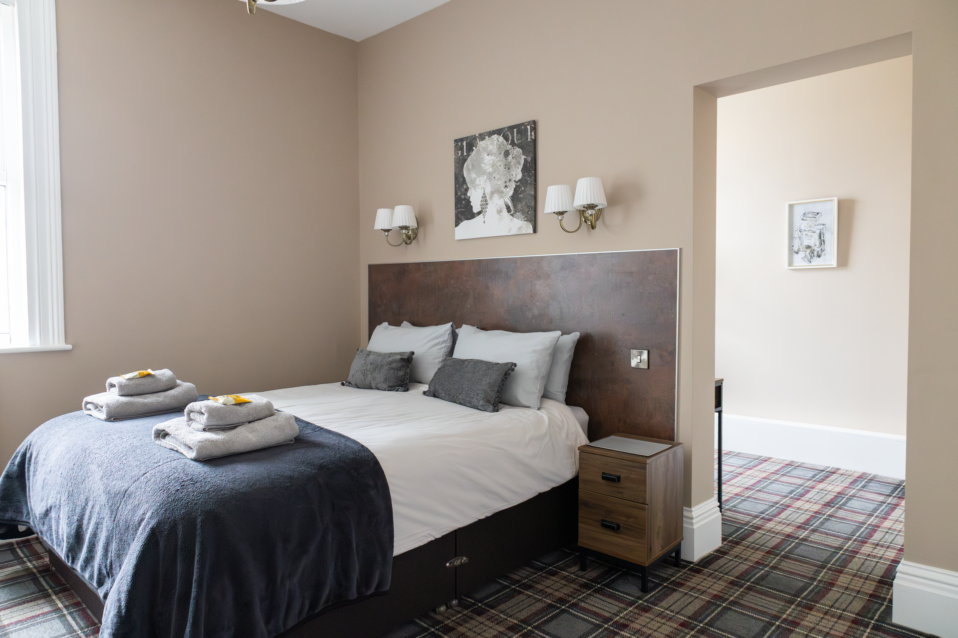 Cozy bedroom with king bed, gray bedding, patterned rug, and soft beige walls