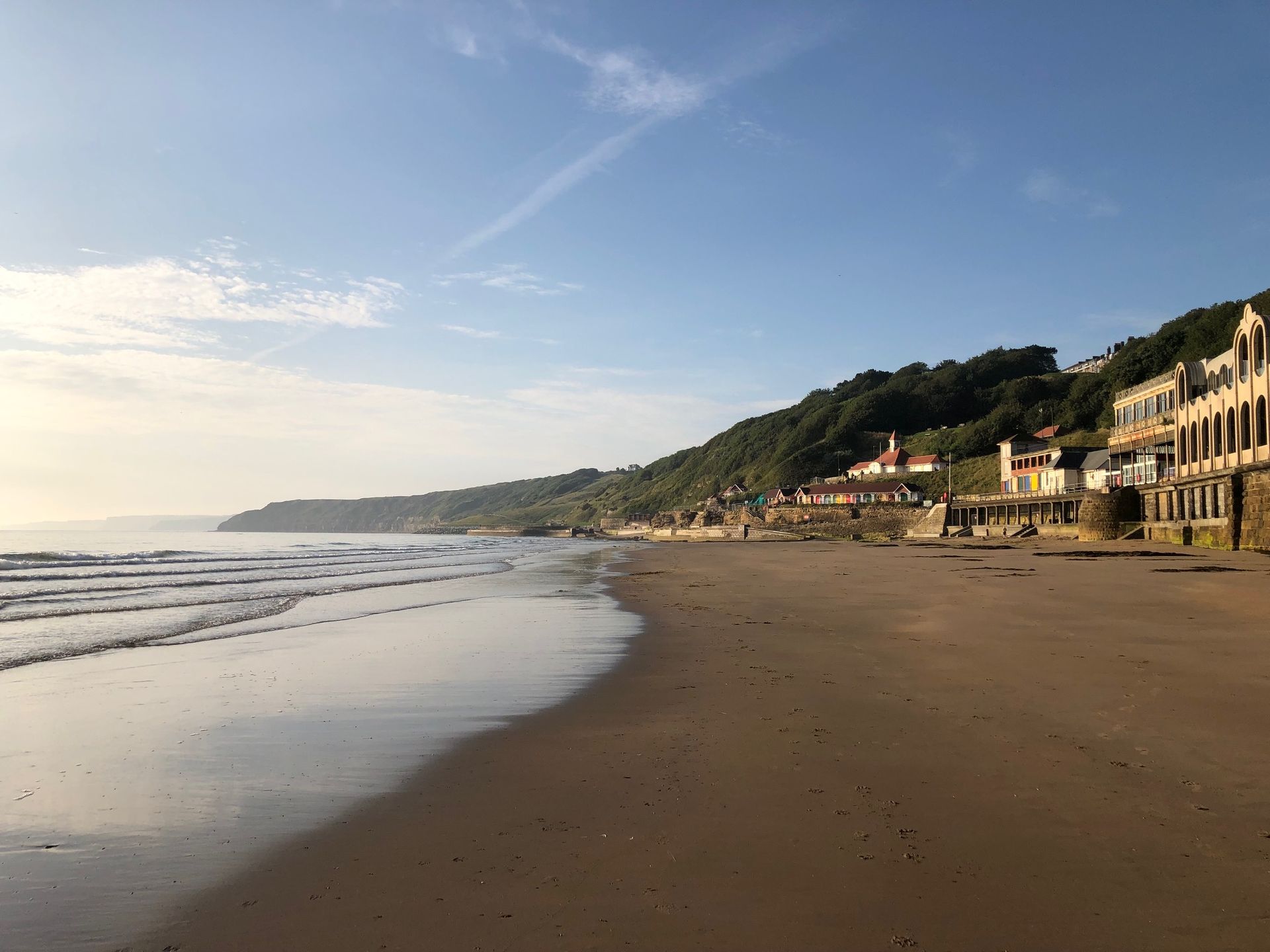 South Bay Beach in Scarborough, looking up towards the colourful beach chalets and the Clock Café on the cliff.