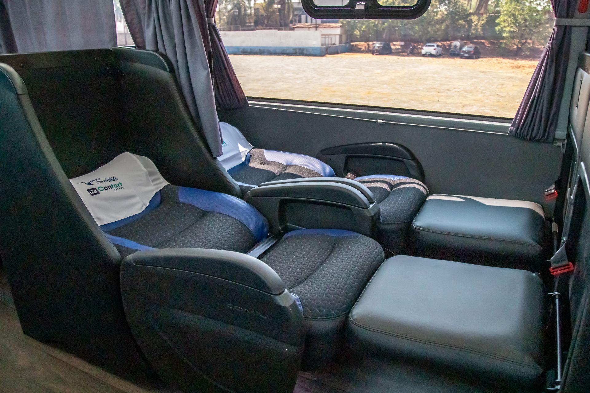 Interior vazio de um carro com bancos de couro escuro e vista pela janela.
