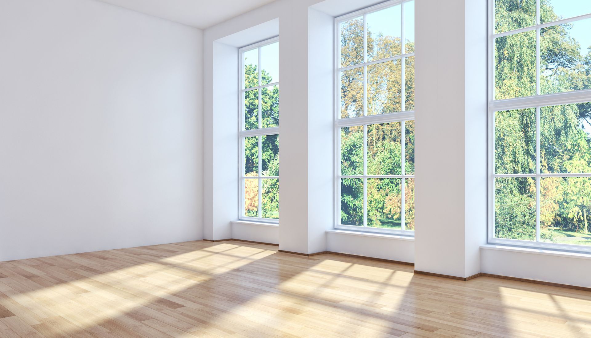 Empty room with three large windows, hardwood floors, and bright sunlight. Empty room with three large windows, hardwood floors, and bright sunlight.