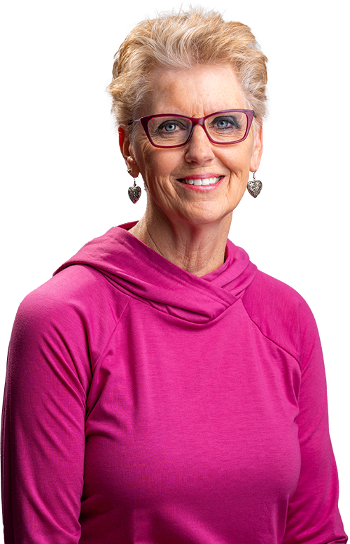 Portrait of a smiling woman in a bright pink top and glasses on a white background