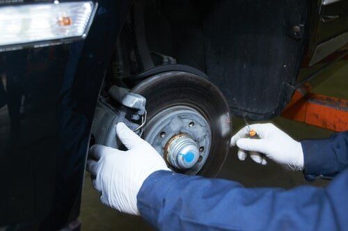 A Person Is Working on The Brake Pads of A Car — Steve Purse Automotive In Huskisson, NSW
