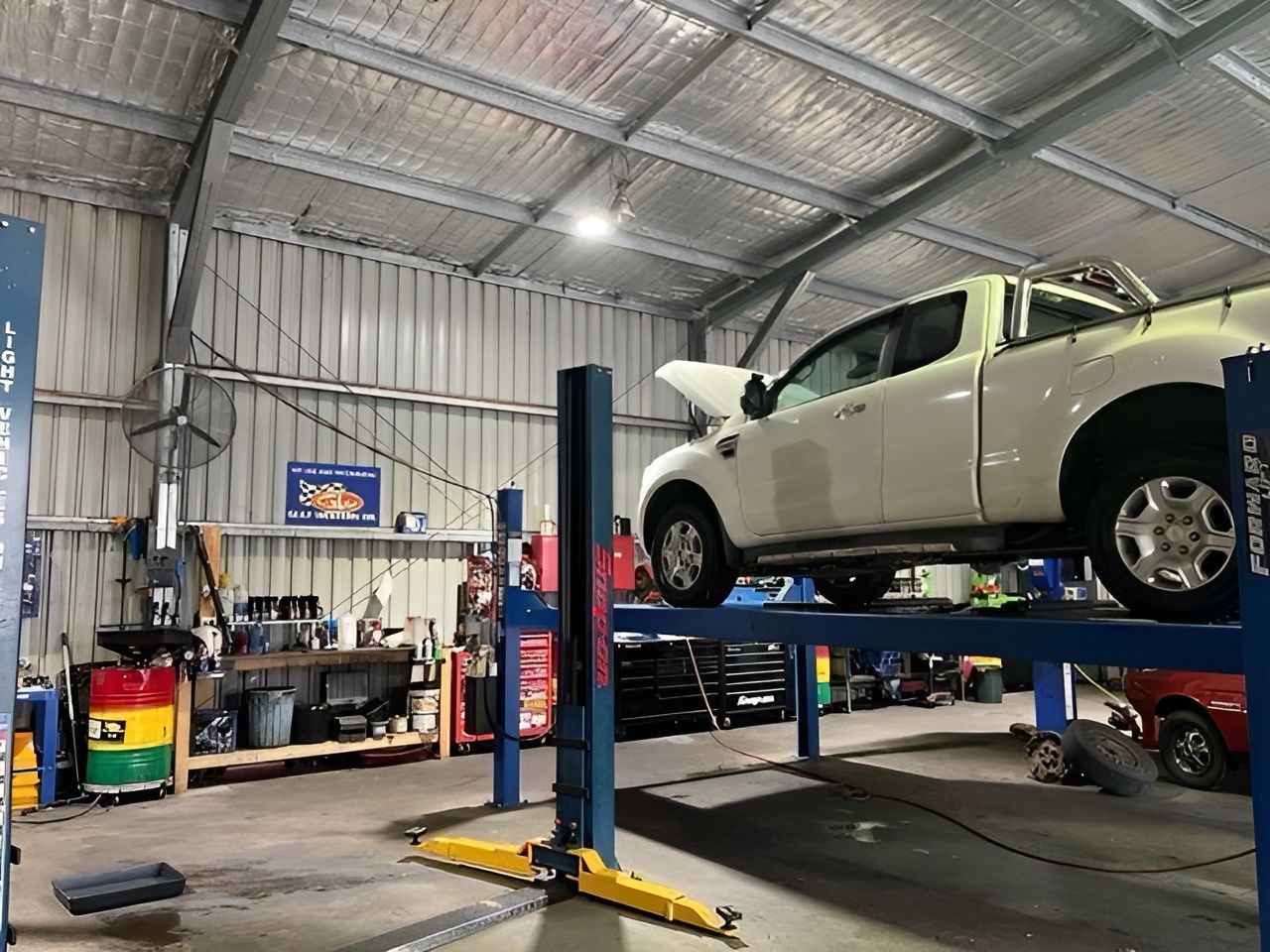 A White Truck Is Sitting on A Lift in A Garage — Steve Purse Automotive In Huskisson, NSW