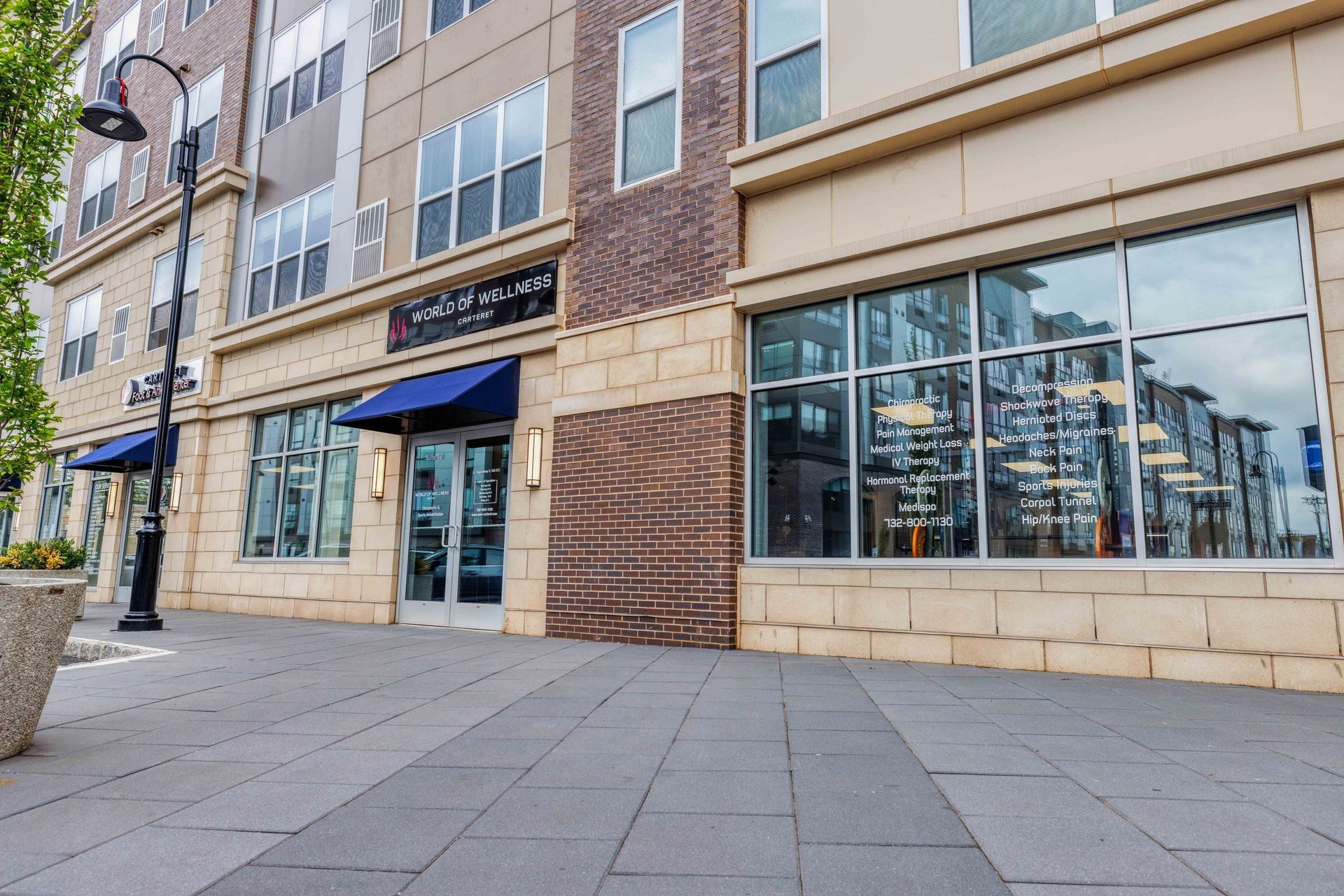 a large building with a lot of windows and a sidewalk in front of it .