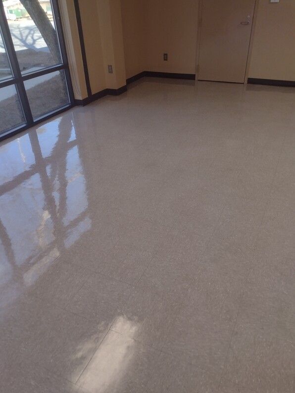Empty beige room with glossy white floor and large windows reflecting light