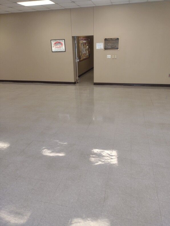 Empty beige hallway with glossy gray floor and an open doorway in the center.