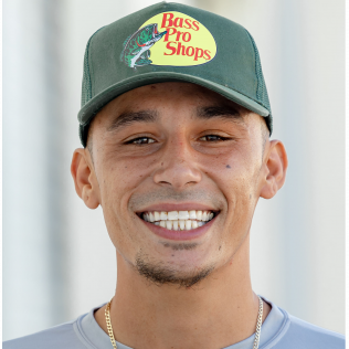 A man wearing a hat that says bass pro shops on it