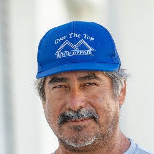 A man with a beard and mustache is wearing a blue hat.