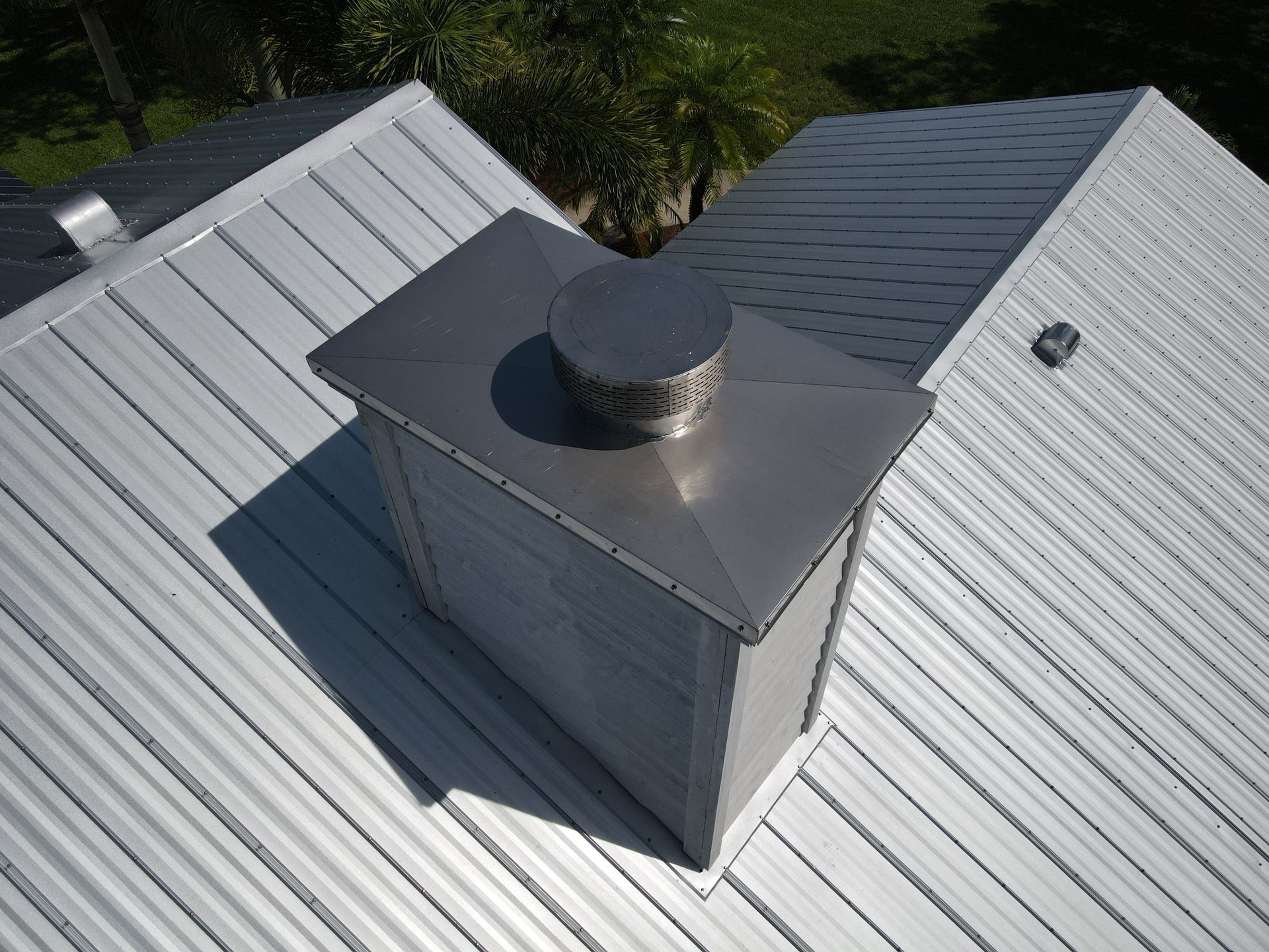 A metal chimney on top of a white roof