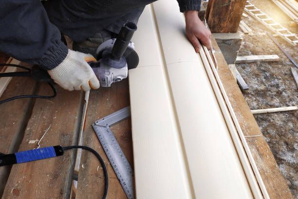 Worker cuts siding to the required size