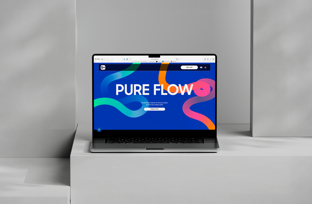 Ein Laptop auf einem grauen Sofa zeigt die blaue Webseite „PURE FLOW“ mit farbenfrohen abstrakten Formen.