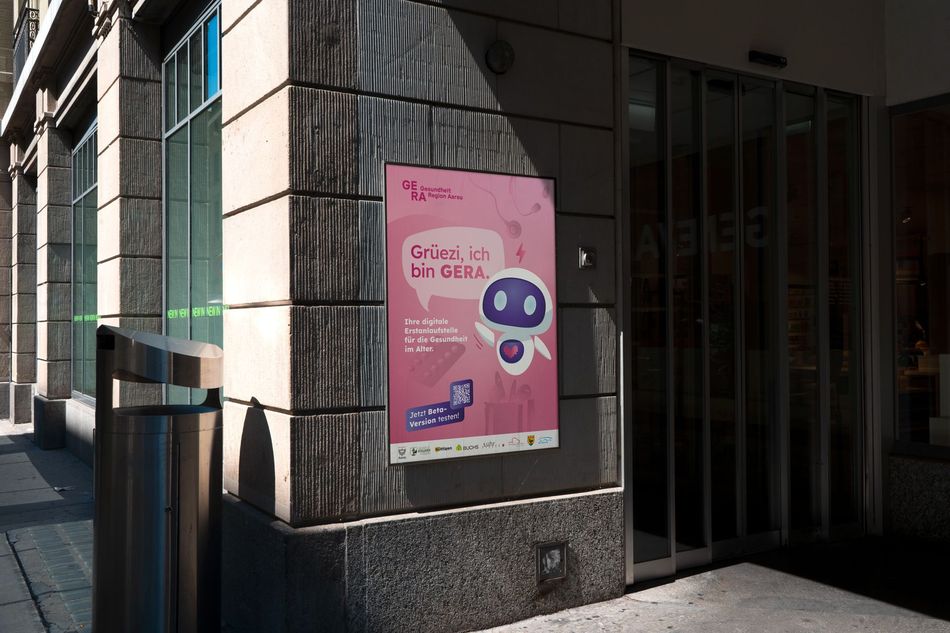 Ein pinkfarbenes Plakat hängt an einer Steinmauer vor dem Eingang eines Gebäudes mit Glastüren und Säulen.