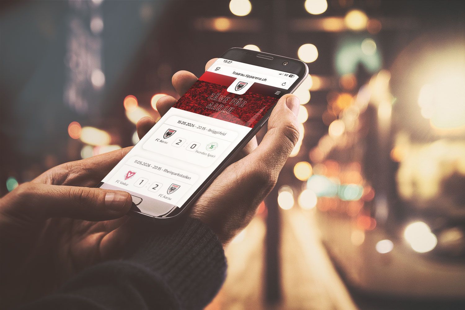 Hände, die ein Smartphone mit geöffneter Shopping-App halten, vor dem verschwommenen Licht der Stadt.