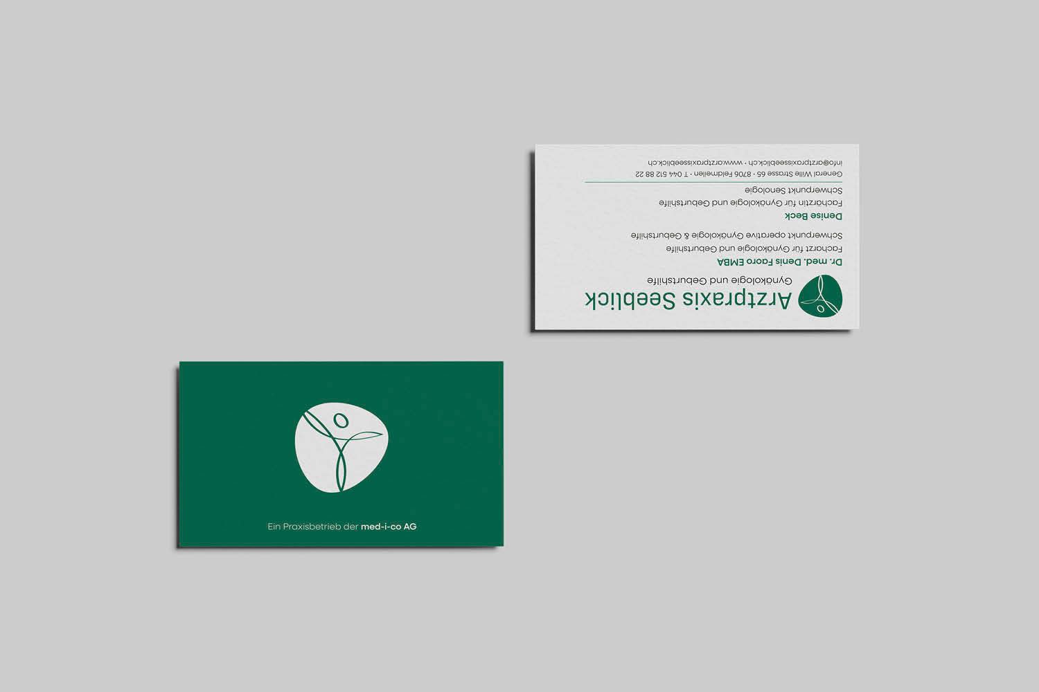 Zwei Visitenkarten auf grauem Hintergrund, eine grüne und eine weiße, beide mit einem kreisförmigen Logo.