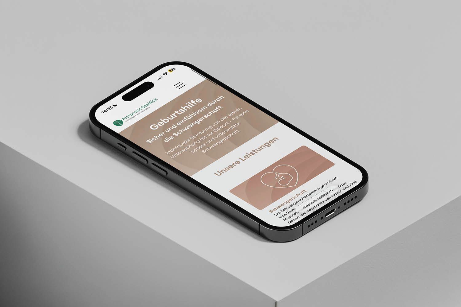 Smartphone mit braun-weißer App-Oberfläche vor grauem Tischhintergrund