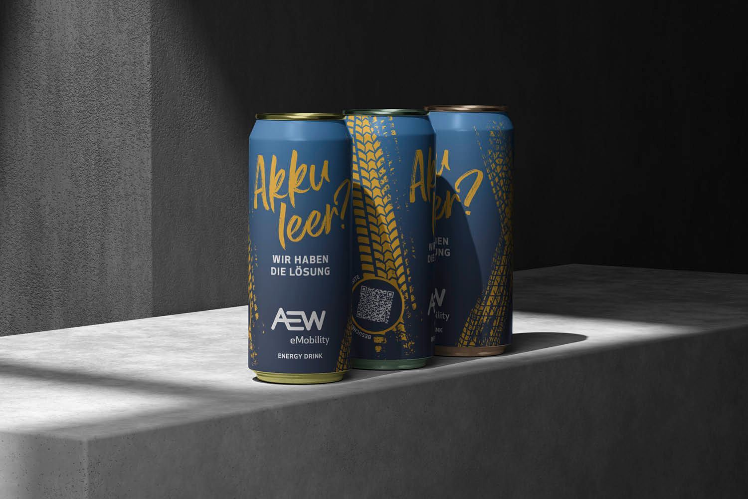 Drei blaue Rockstar Energy-Dosen auf einem grauen Sims in einem schwach beleuchteten Studio.