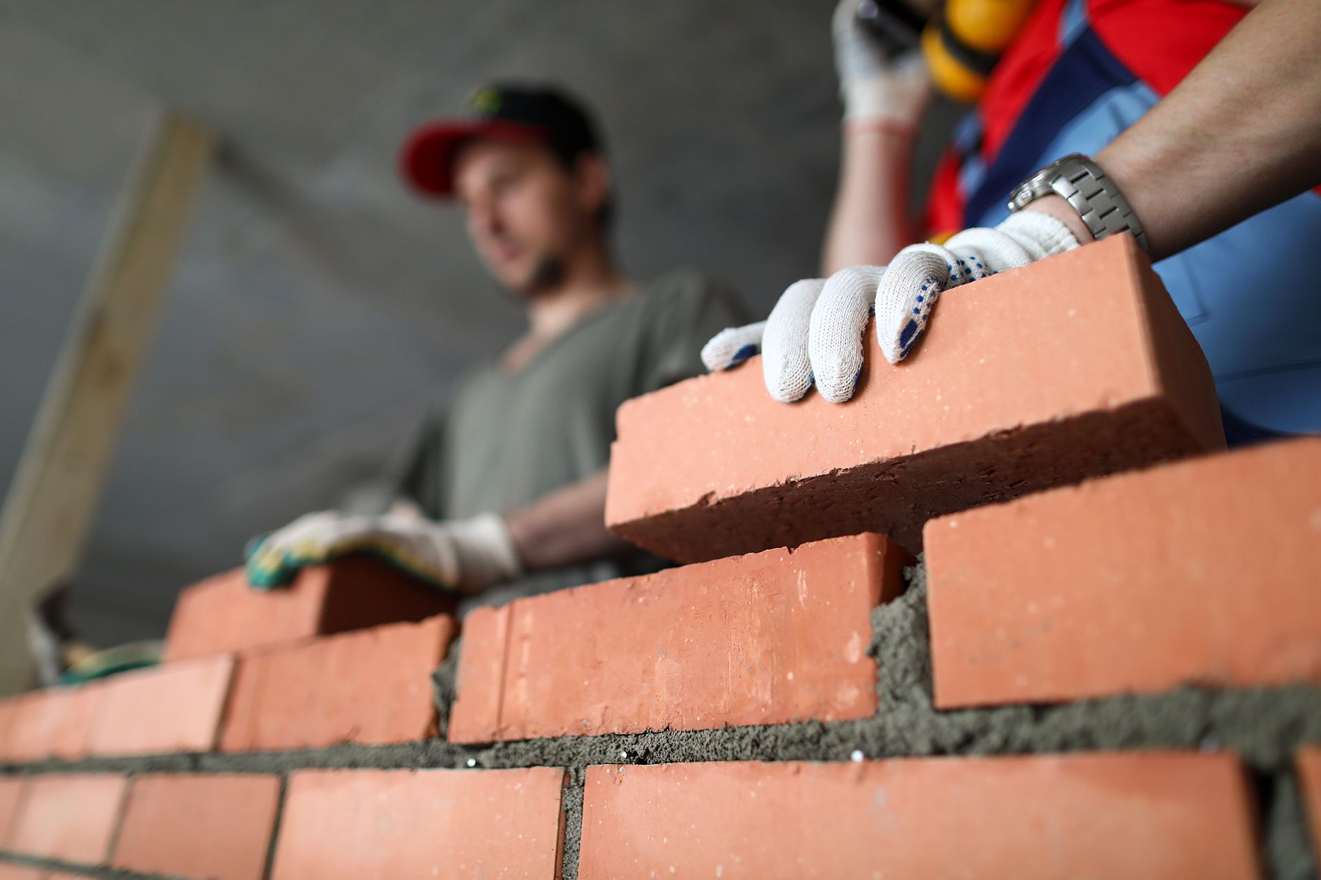 Man Laying Bricks on Top of a Brick Wall