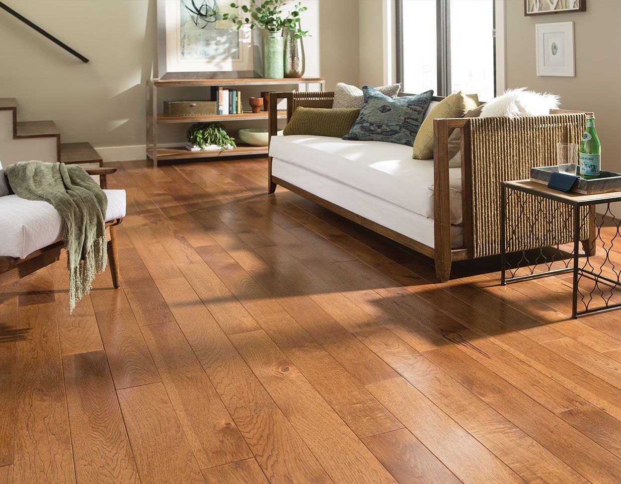 A living room with hardwood floors and a white couch
