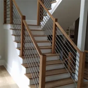 A wooden staircase with a stainless steel railing