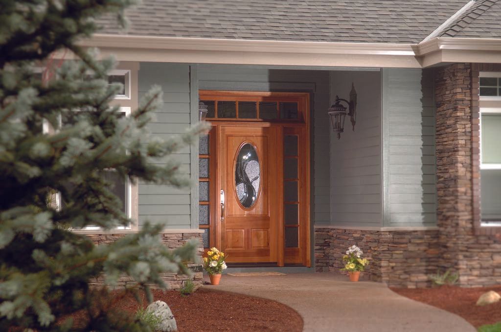 A house with a wooden door and a green siding