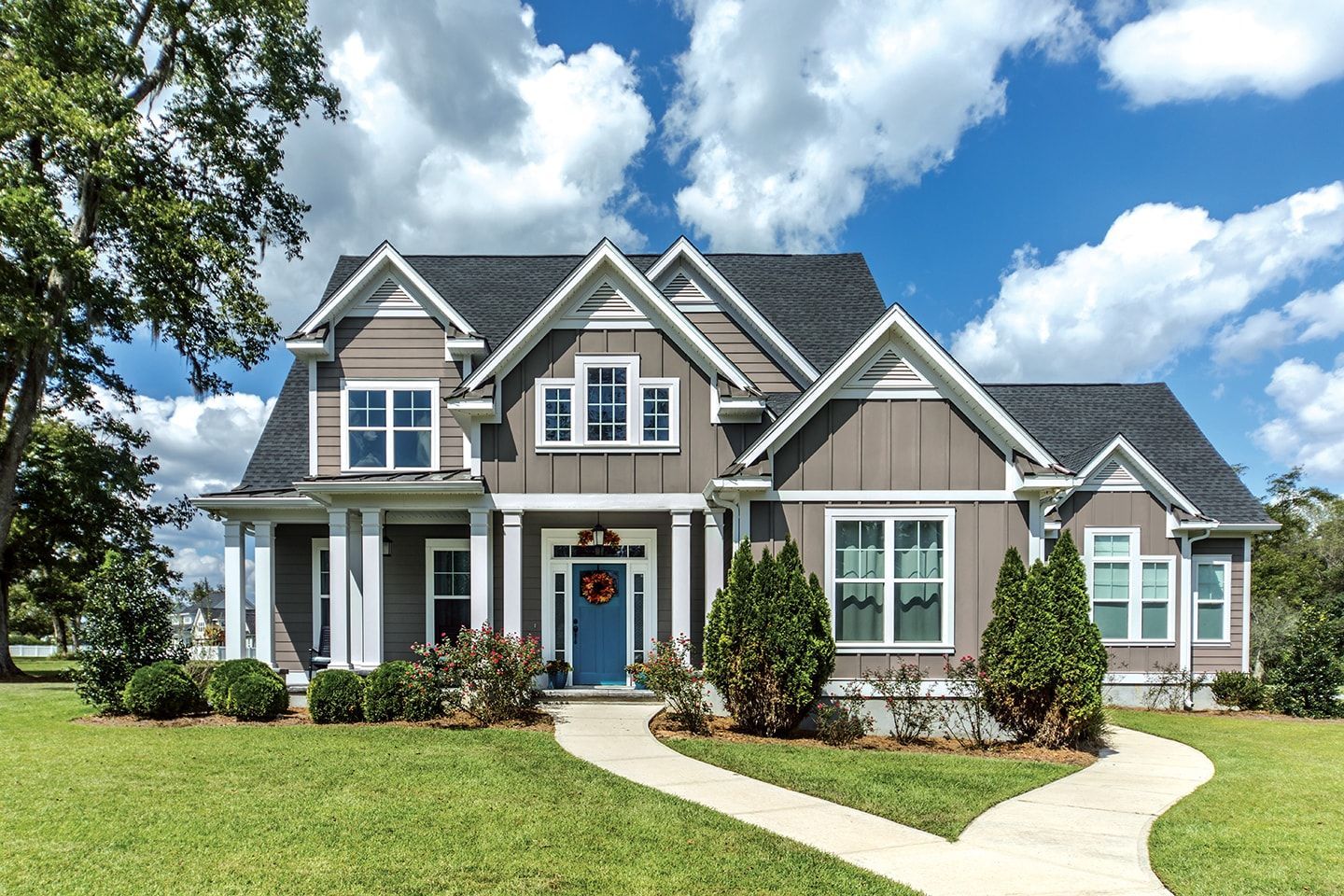 A large house with a blue door and a walkway leading to it.