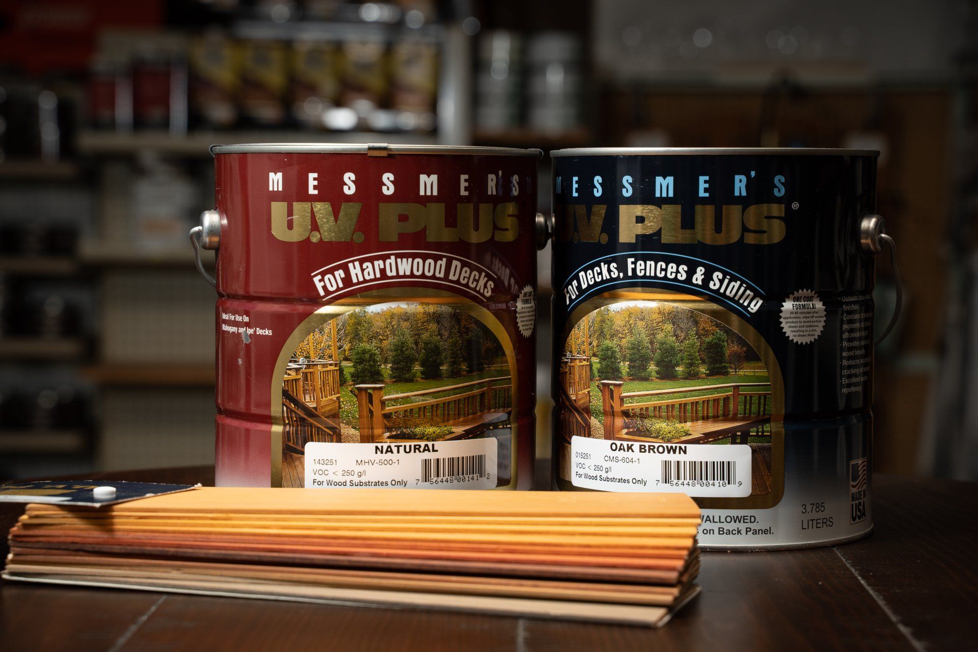 Two cans of uv plus wood stain are sitting on a wooden table.