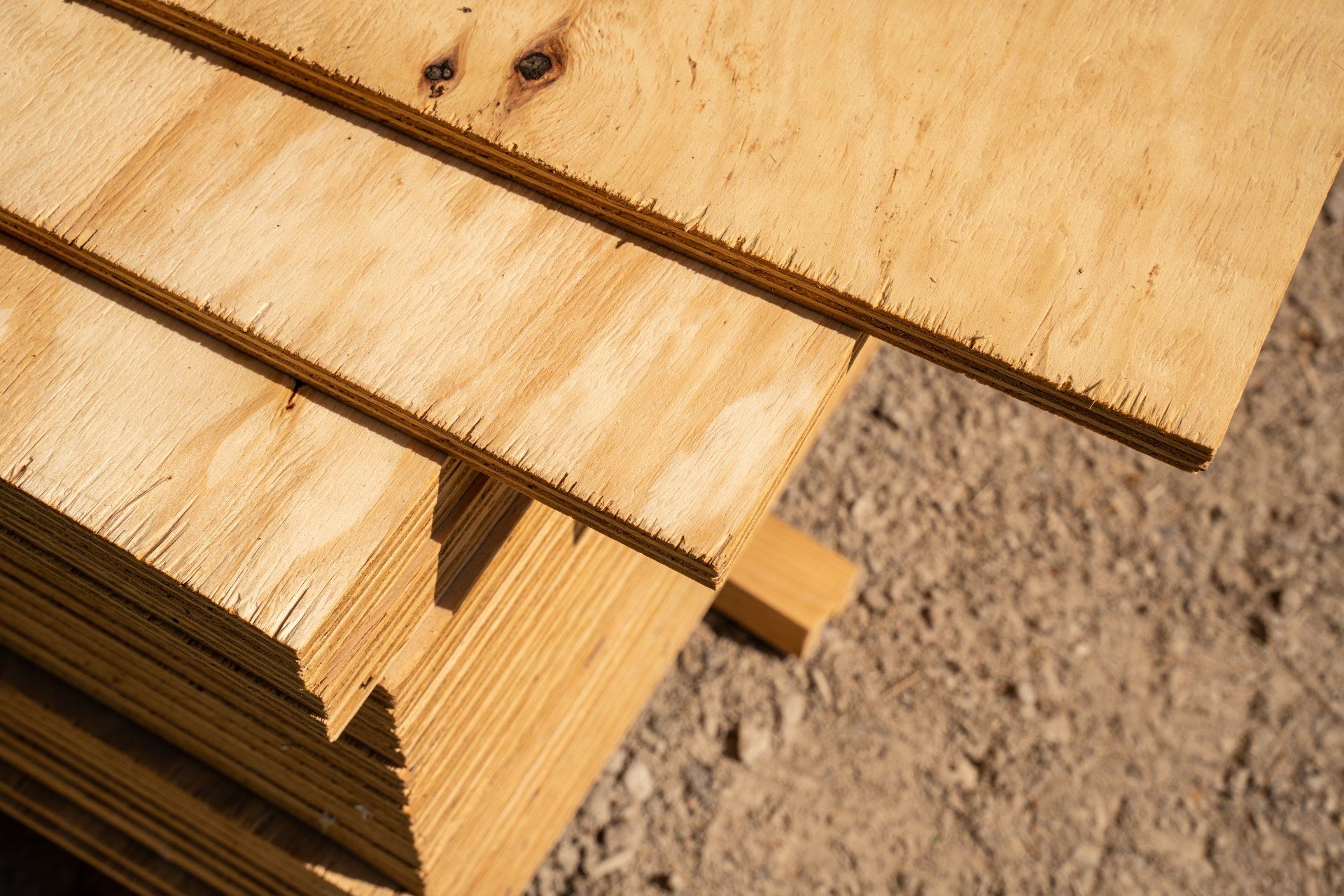 A stack of plywood is sitting on top of a pile of dirt.