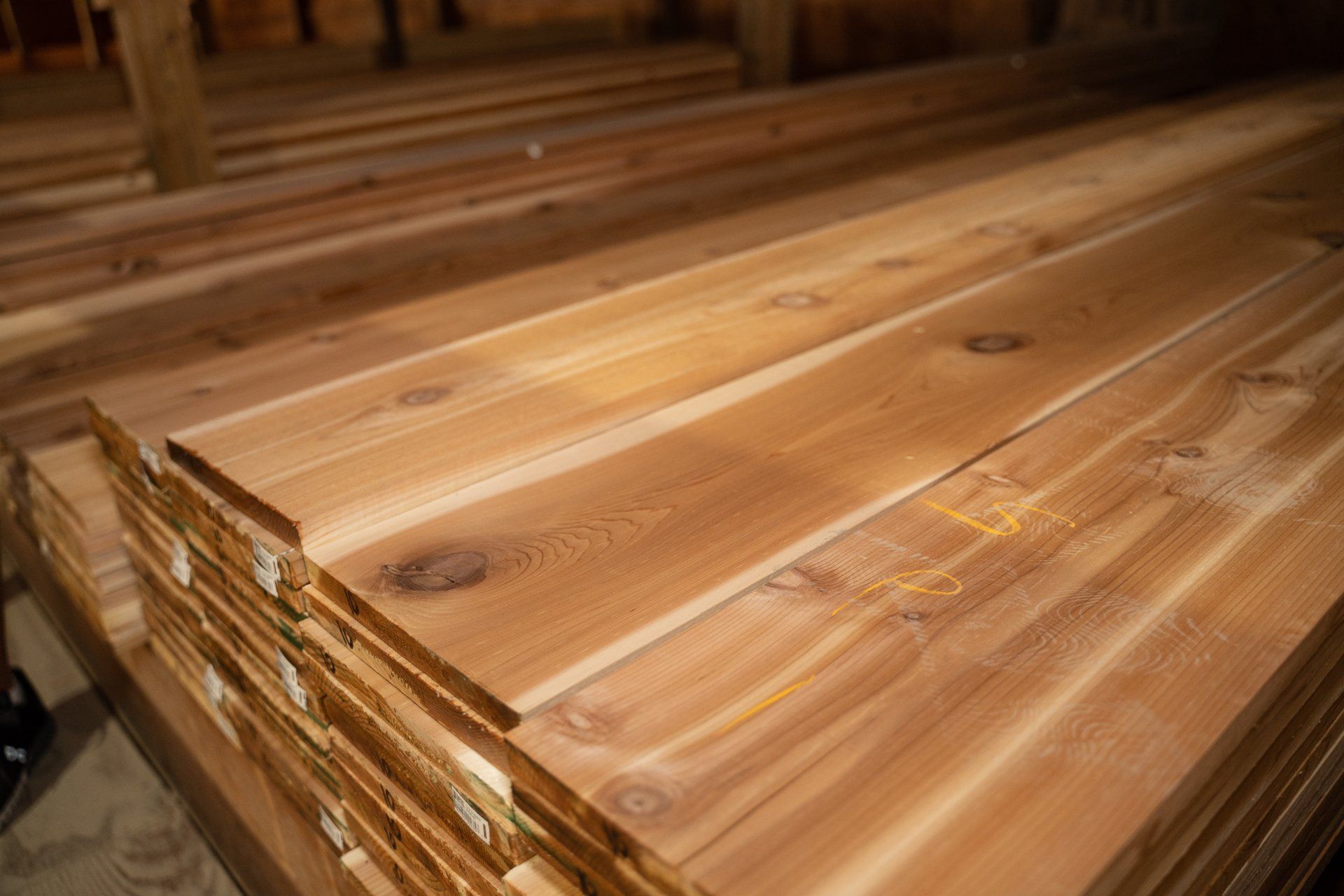 A stack of wooden planks sitting on top of each other in a warehouse.