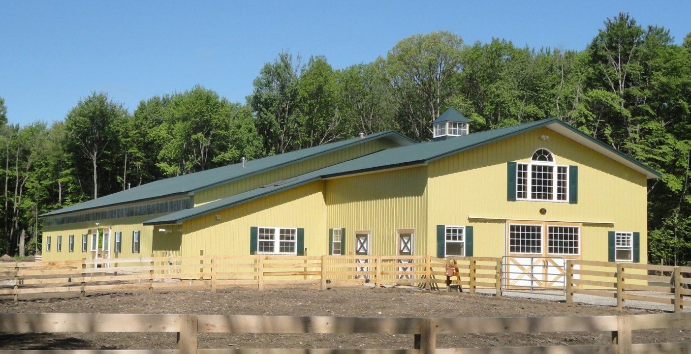 A large yellow building with a green roof and white shutters