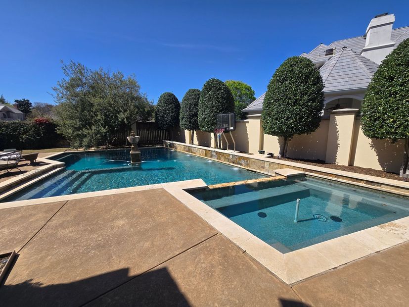 Backyard with a swimming pool, hot tub, and patio under a clear blue sky