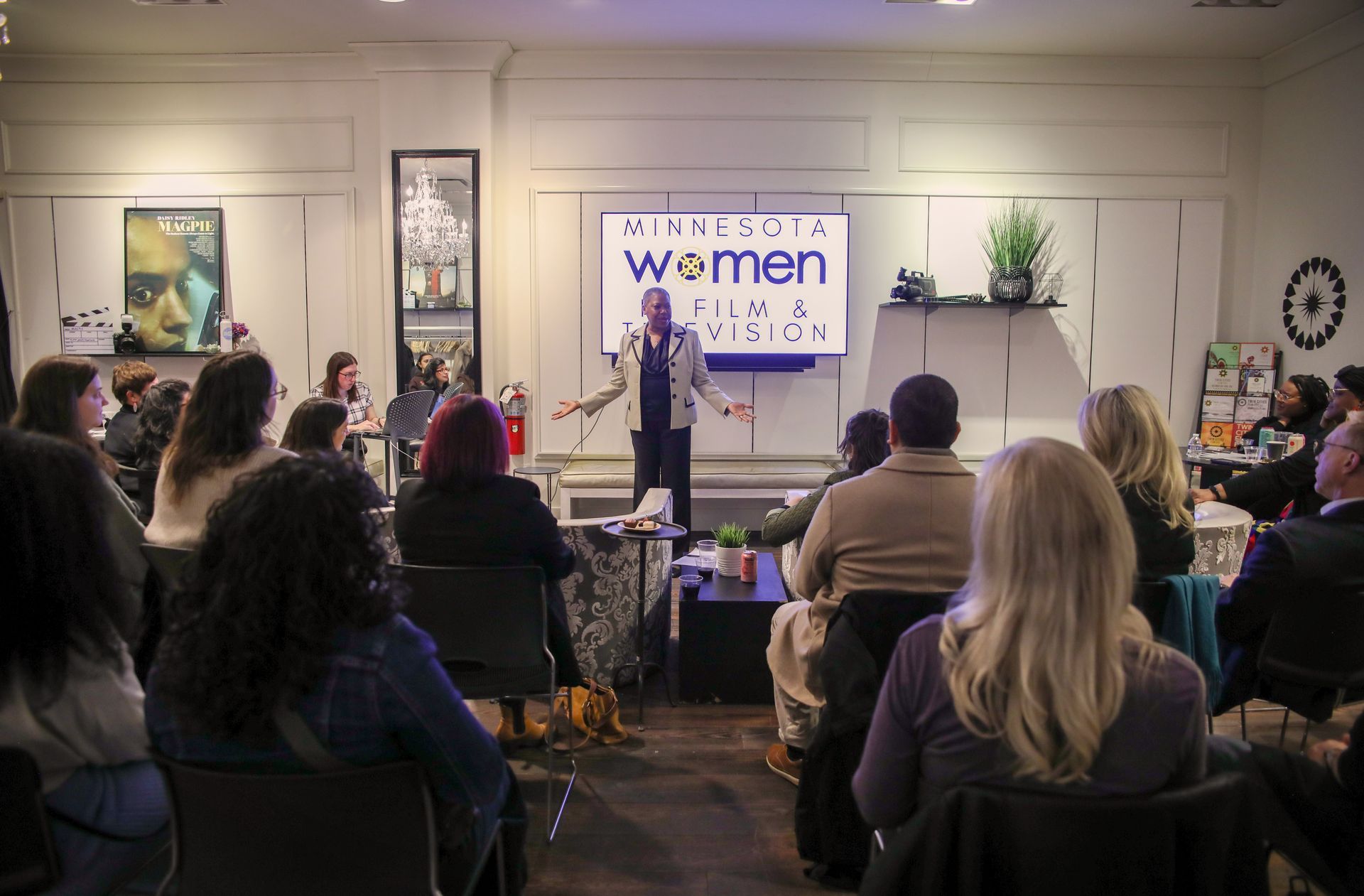 A woman is giving a presentation to a group of people in a room.