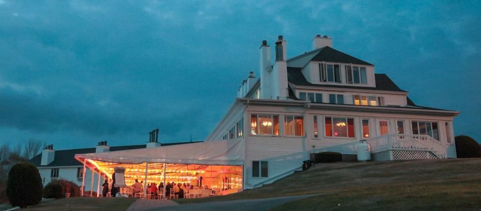 A large white house is lit up at night.