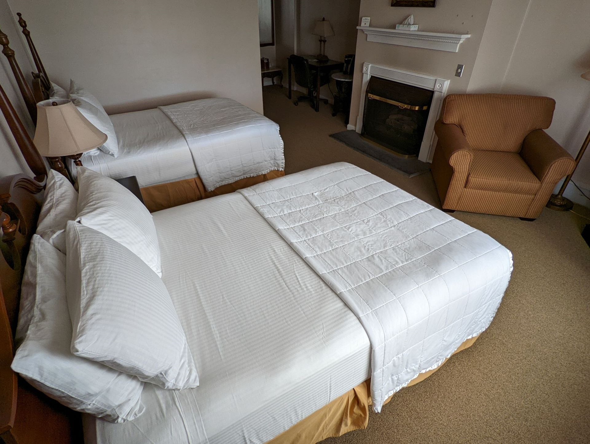 A hotel room with two beds and a fireplace