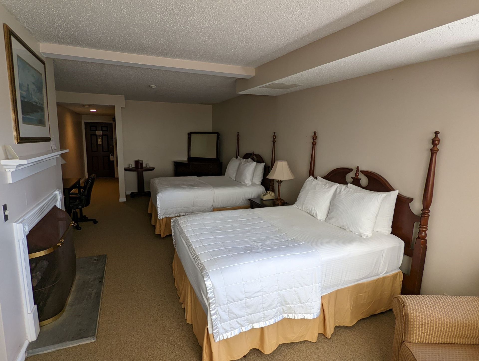A hotel room with two beds and a fireplace
