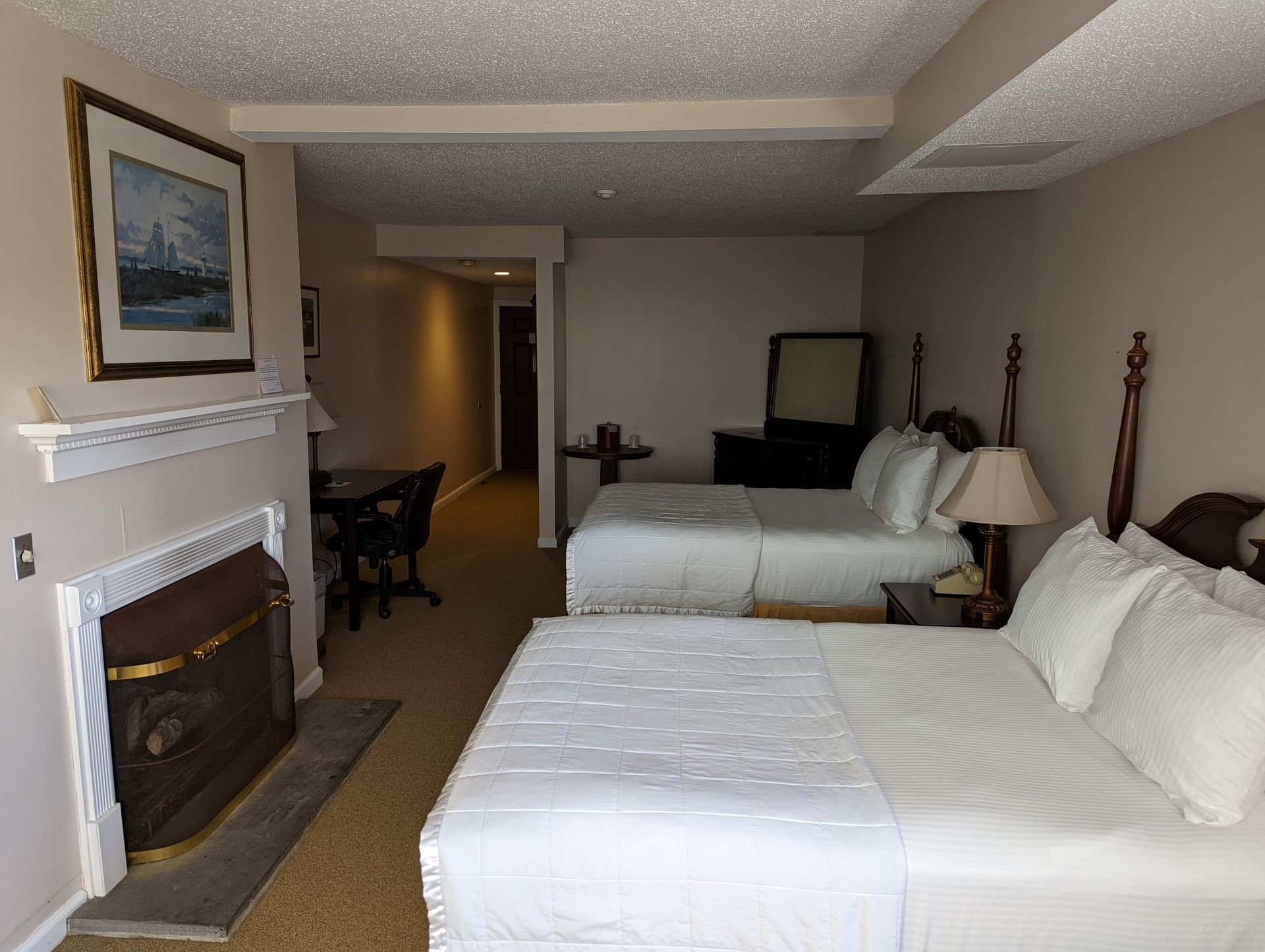 A hotel room with two beds and a fireplace
