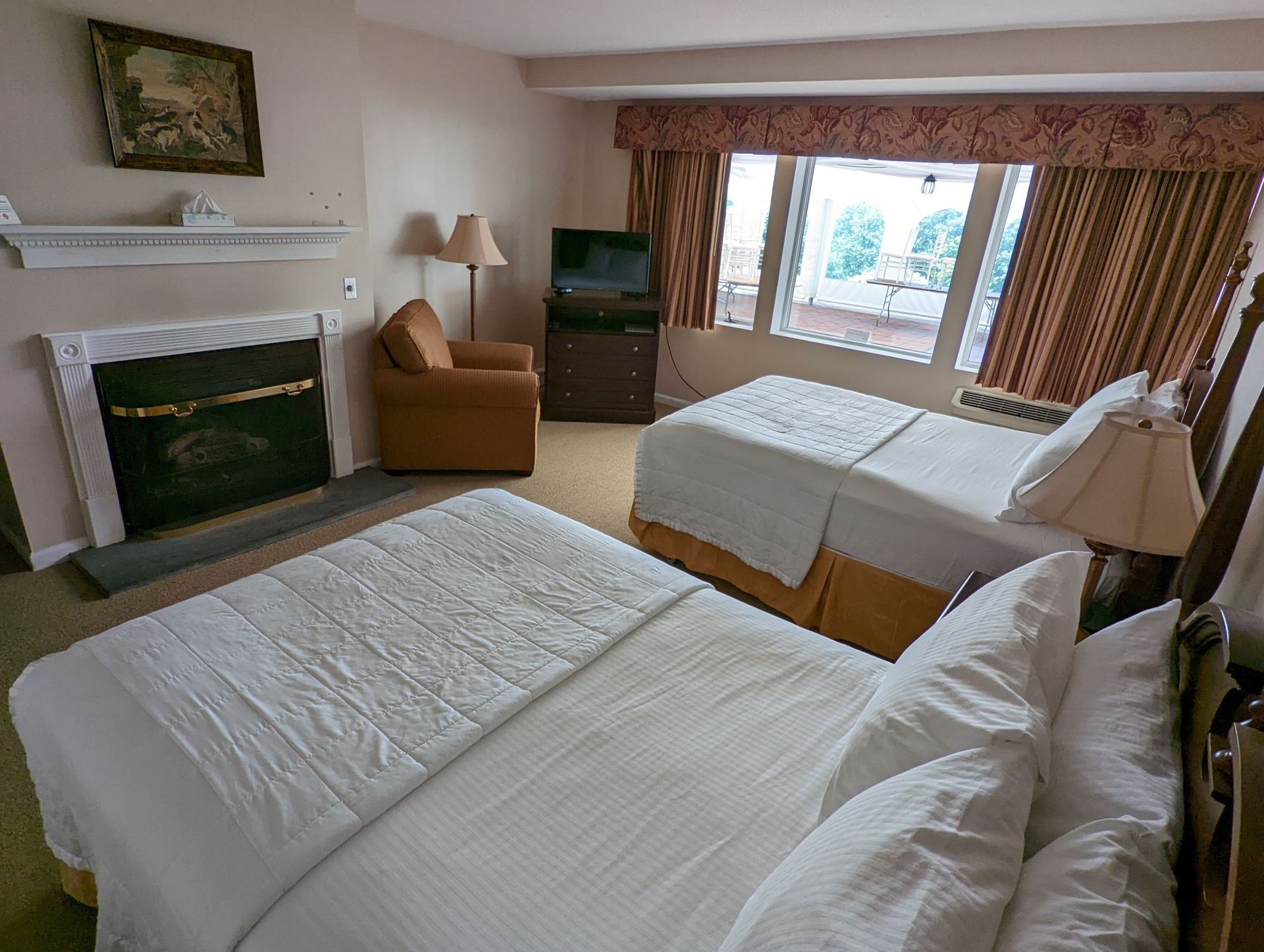 A hotel room with two beds and a fireplace