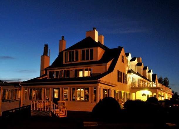 A large house with many windows is lit up at night