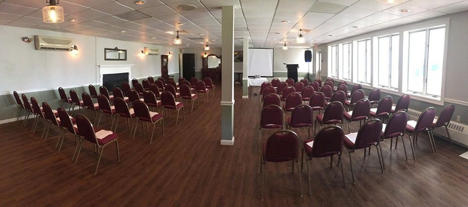 A large room filled with rows of chairs and tables.