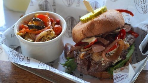 A sandwich and a bowl of vegetables on a table