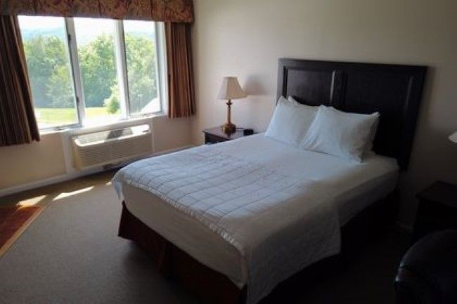 A hotel room with a bed and a window
