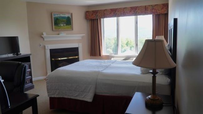 A hotel room with a king size bed and a fireplace