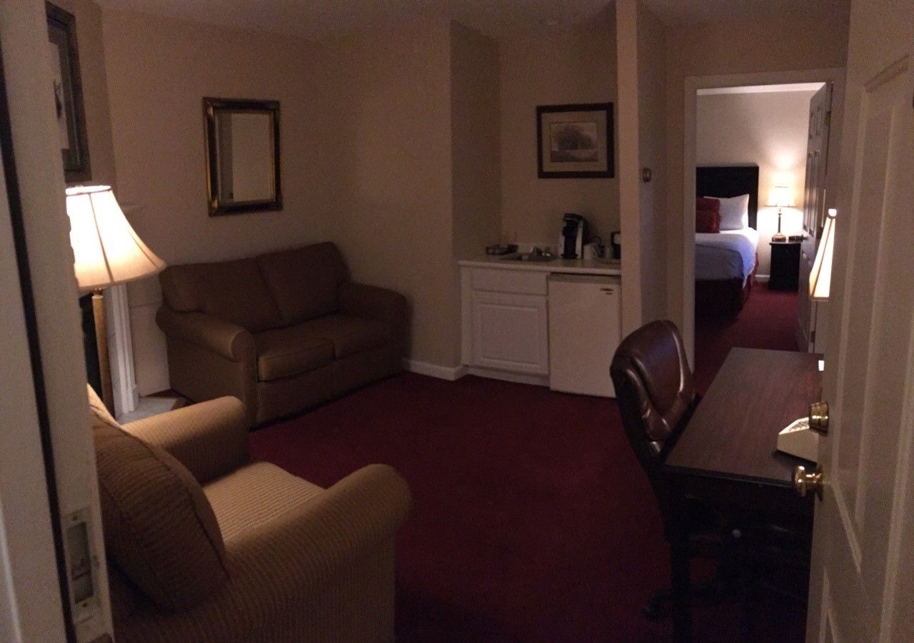 A hotel room with a couch a chair and a desk