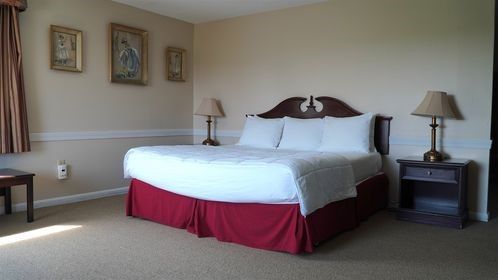 A hotel room with a king size bed and two lamps