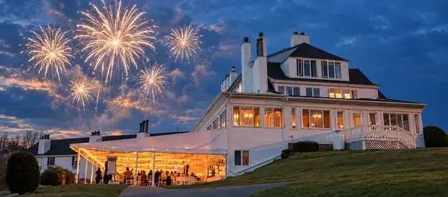 A large white house is lit up at night.
